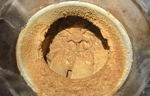 Exhaust fan inlet and wheel buried under heavy grease accumulation before cleaning