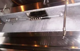 The same hood plenum cleaned to bare stainless steel after PowerClean service